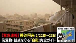 2026年2月22日夜〜23日の黄砂飛来を警告するアイキャッチ。黄砂で霞む都市部とベランダの洗濯物、マスクを着用した防災教官クロマルが予測マップで警告する様子を描写 。